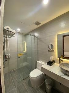 a bathroom with a shower and a toilet and a sink at A25 Hotel - 14 Hồ Huấn Nghiệp in Ho Chi Minh City