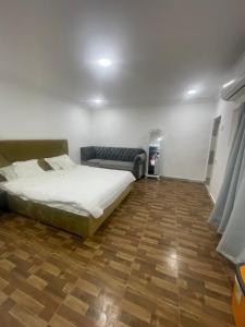 a bedroom with a bed and a wooden floor at نزل نسيم الحمراء - nseem alhamra inn in Al Ḩamrāʼ