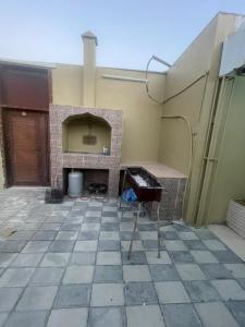 a patio with a stone fireplace in a house at نزل نسيم الحمراء - nseem alhamra inn in Al Ḩamrāʼ