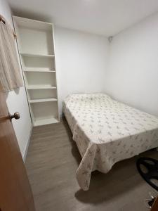 - une petite chambre avec un lit et des étagères dans l'établissement Hermosa Casa y barbacoa en Balneario Solís con gran parque, a una cuadra de el mar, à Solís