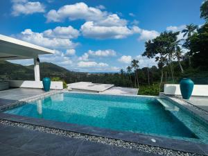 a swimming pool with a view of a house at VILLA CHLOE - SEAVIEW - 4 Bedrooms in Koh Samui