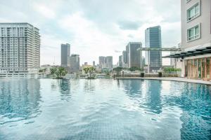 a swimming pool in a city with tall buildings at Dua Sentral Residence near KL Sentral by COBNB in Kuala Lumpur