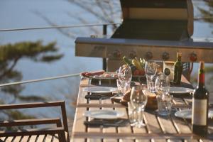 a picnic table with wine glasses and a grill at Buckeye House by the lake in Yamanakako