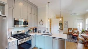 Una cocina con gabinetes blancos y un horno de estufa. en PAMMY'S OAKS AND SAND OCEAN OAKS Duplex, en Jekyll Island 22 fotos más