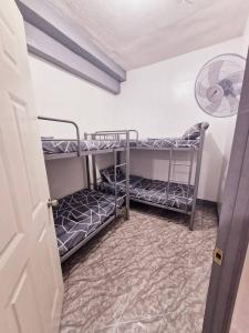 2 literas en una habitación con ventilador en Budget Transient Near Burnham Park, en Baguio