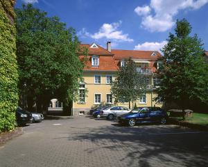 a parking lot in front of a large building at Badischer Hof in Tauberbischofsheim