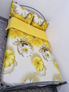 1 cama con 2 almohadas con flores amarillas y blancas en Budget Transient Near Burnham Park, en Baguio 17 fotos más