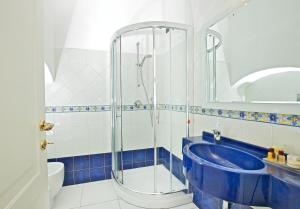 a bathroom with a shower and a blue tub at Hotel San Michele in Anacapri