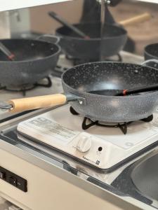 a frying pan on top of a stove with pans at 新大久保から徒歩7分の新しいアパート1 in Tokyo