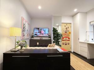a living room with a couch and a tv at Perfect Potts Point Pied-à-terre in Sydney