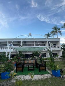 a building with benches in front of it at Coast Side Cliffs Resort in Talisay