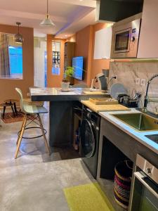 a kitchen with a sink and a washing machine at Le DODU in Saint-Denis