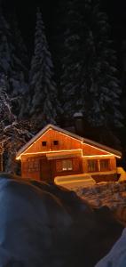 a large wooden cabin with snow on it at night at Вила Рози, Семково in Belitsa +37 photos