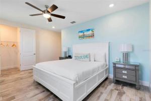 a bedroom with a white bed and a ceiling fan at Margaritaville Florida Getaway in Orlando