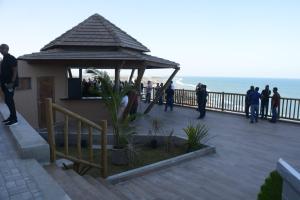 a group of people standing on a deck near the ocean at Duplex Belli a 300m do Mar in Natal
