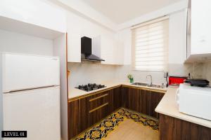 a kitchen with a white refrigerator and wooden cabinets at Don Residencies & Apartments Dehiwala - Mount Lavinia in Colombo +35 photos
