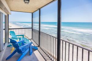 卫星海滩You Cannot Get Any Closer To The Beach! 2br Condo的阳台上配有两把蓝色椅子,俯瞰着大海
