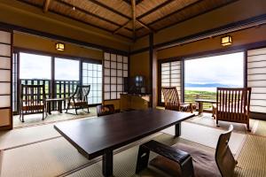 a room with a table and chairs and windows at Ichiboukan Hanare Kai in Kyotango