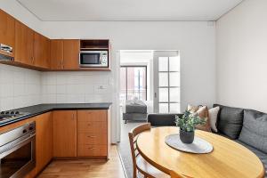 a kitchen and living room with a table and a couch at Retreat Horizons - Spacious Perth CBD 1BR in Perth