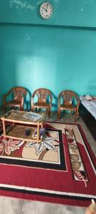 sala de estar con mesa, sillas y reloj en Daya Home Stay 1 km to Sangam Mahakumbh, en Prayagraj