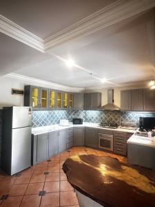 a kitchen with white cabinets and a white refrigerator at Tropical Pool Villa Langkawi in Pantai Cenang