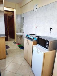 a kitchen with a stove and a sink in it at Ayo's Vacation Home in Thika