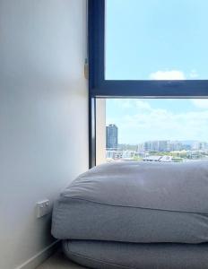 a bed in a room with a window at Modern 5-Guest Pool Retreat for Family & Business in Brisbane +6 photos