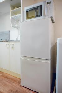 a white refrigerator with a microwave on top of it at Coda House in Aoichō +26 photos