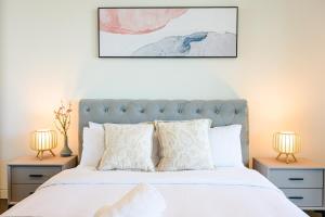 a bedroom with a white bed with two night stands at Lidcombe Apt Near Olympic Park Train in Sydney +20 photos