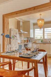 a kitchen with a wooden table with wine glasses on it at Koté Vagues - Appt pieds dans l'eau in Saint-Gilles les Bains