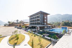 a large building with a swimming pool in front of it at Triple Crown Resort in Dhāding