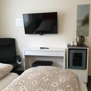 ein Schlafzimmer mit einem TV an der Wand und einem Bett in der Unterkunft Hotel Römerhof in Brigerbad