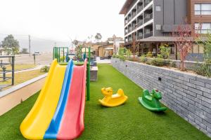 a playground with slides and toys on the grass at Triple Crown Resort in Dhāding