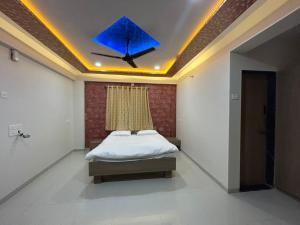 a bedroom with a bed with a blue object on the ceiling at Shourya Homes in Arvi