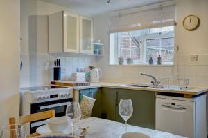 - une cuisine avec une table et deux verres à vin dans l'établissement Rose Cottage by Winterton Cottages, à Winterton-on-Sea