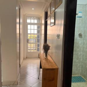 a hallway with a table with a vase of flowers on it at Koselig California in Nanyuki +20 photos