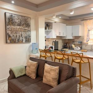 a living room with a couch and a kitchen at Koselig California in Nanyuki