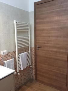 a bathroom with a wooden door and a sink at Sale e Vele Apartments in Trapani +62 photos