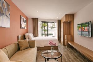 河内An Nguyen Lakeside Residence的一间配有床、沙发和桌子的酒店房间