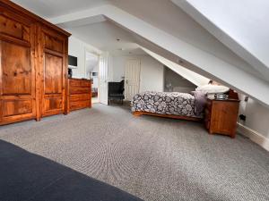 a bedroom with a bed and a desk and a staircase at Rooms36 in Keswick