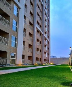 a large apartment building with a green lawn in front of it at Classy 2bhk near Yelahanka in Yelahanka