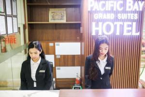 two women are standing in a hotel room at Pacific Bay Grand Suites in Manila +55 photos