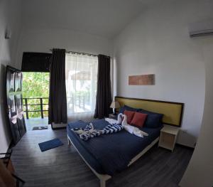 una camera con un letto con due persone sopra di Adroit Sunset View a Guraidhoo
