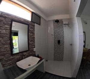 un bagno con lavandino e doccia con specchio di Adroit Sunset View a Guraidhoo