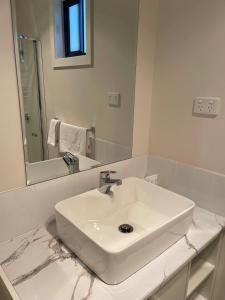 Robinvale Murray View Cabin的带水槽和镜子的白色浴室