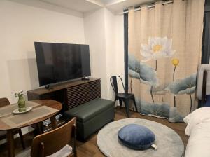 a living room with a flat screen tv and a table at Liam and Linus Condo 1 Studio Type in Baguio