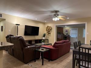 ein Wohnzimmer mit Sofas und einem Flachbildfernseher in der Unterkunft 4 Bedrm 2 Ba Office WiFi Hiking House Central Phx in Phoenix