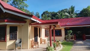 a house with a red roof and a patio at Jovick Homestay in Siquijor
