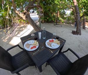 un tavolo nero con piatti di cibo sopra di Adroit Sunset View a Guraidhoo