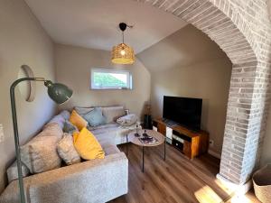 a living room with a couch and a tv at Reetdachkate am Deich in Seester